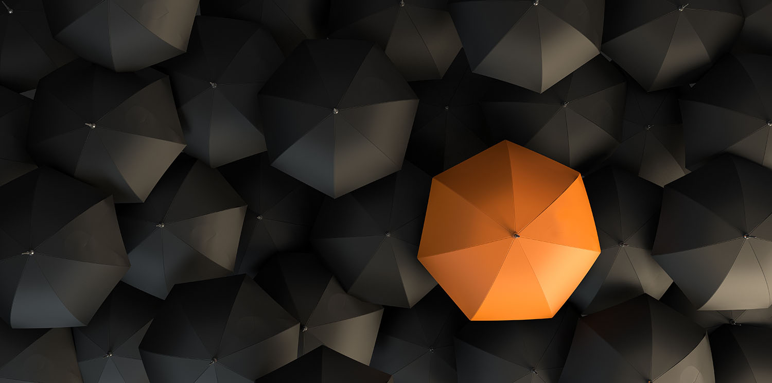 A group of umbrellas with one orange umbrella in the middle.